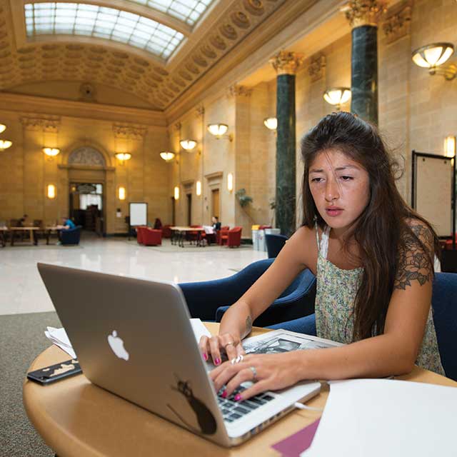 Female student looking at a Mac laptop
